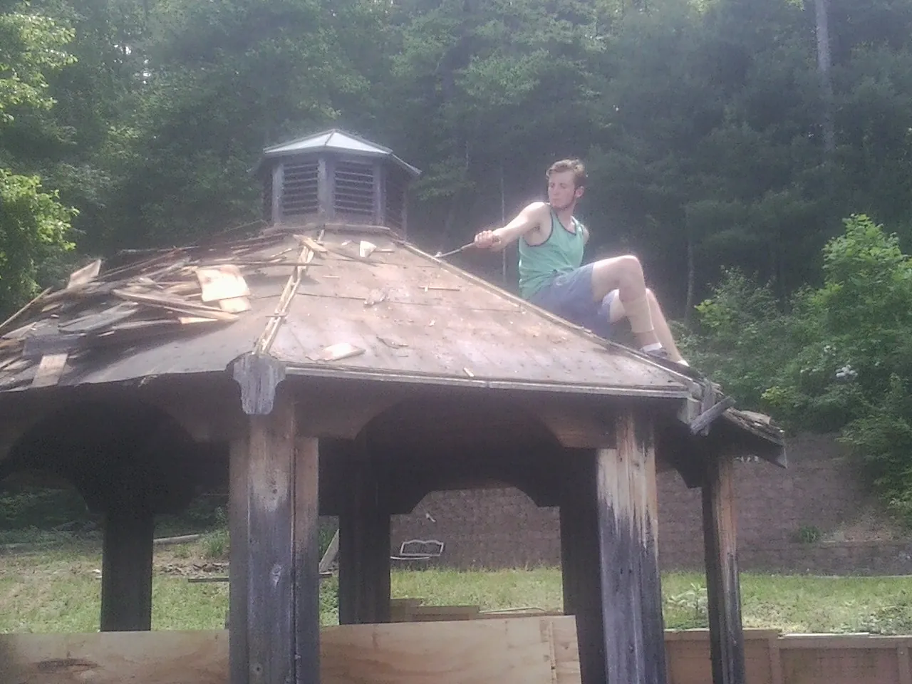 Tearing the old roof off a wooden gazebo before new shakes in Spring City