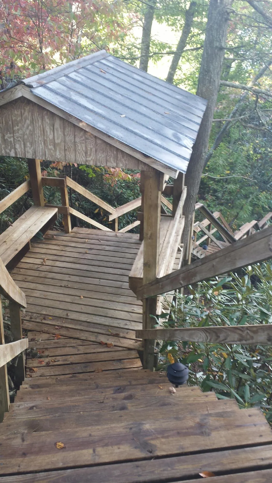 Metal roofed shelter over wooden steps on a wooded walkway — Skylight Repair & Installation work by our crew in Spring City